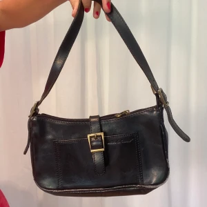 Handväska  - Dragkedjan funkar inte men den stängs bra med knappen. Lite slitning