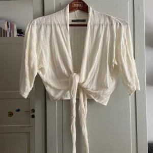 Bolero / kofta - Kort kofta el bolero med omlottknytning, fin till bröllop t.ex. Krämvit och hål