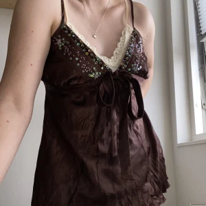 Y2K linne festtopp  - Säljer min gamla Y2K topp från 2000-talet som jag älskar men som inte är min stil längre! Köpt i USA! Built-in lace linne. Finns knytband i ryggen. Står strl L men passar mig som bär S! 