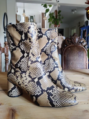 Ankelboots i syntetiskt ormskinn - Lite slitna undertill annars jättefint skick.