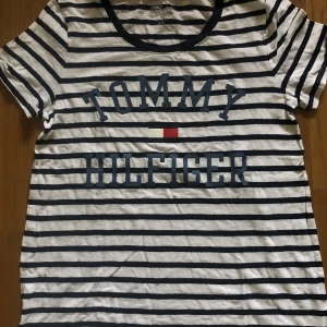 Tommy Hilfiger tshirt  - En jättefin randig Tommy Hilfiger t-shirt som inte kommer till användning längre. tröjan har blåa ränder & har en lös passform! 