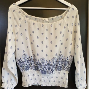 Mönstrad blus - En vit och blå mönstrad blus med resår i botten. Storlek 134/140 från Kappahl 🩷 Enda defekten är att resåren på toppen har börjat lägga av. 