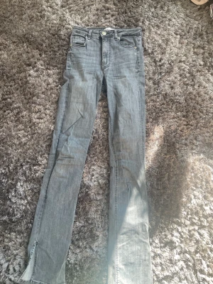 Gråa jeans - Jag säljer dessa jeans för att dem inte längre passar, de har slits längst ner, högmidjade och ena bandet håller på och lossna, men dem är jätte sköna och passar perfekt nu när de börjar bli lite kallare igen. 💕