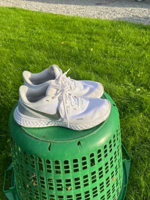 Nike Revolution strlk 40,5  - Ett par skitsnygga och fräscha springskor i storlek 40,5. Krämvita och väldigt clean design. 