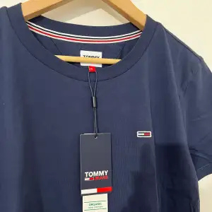 En marinblå t-shirt från Tommy. Den är helt ny. Storlek XL men den är lite i storlek så den passar de som har storlek L/M. Köparen står för frakt