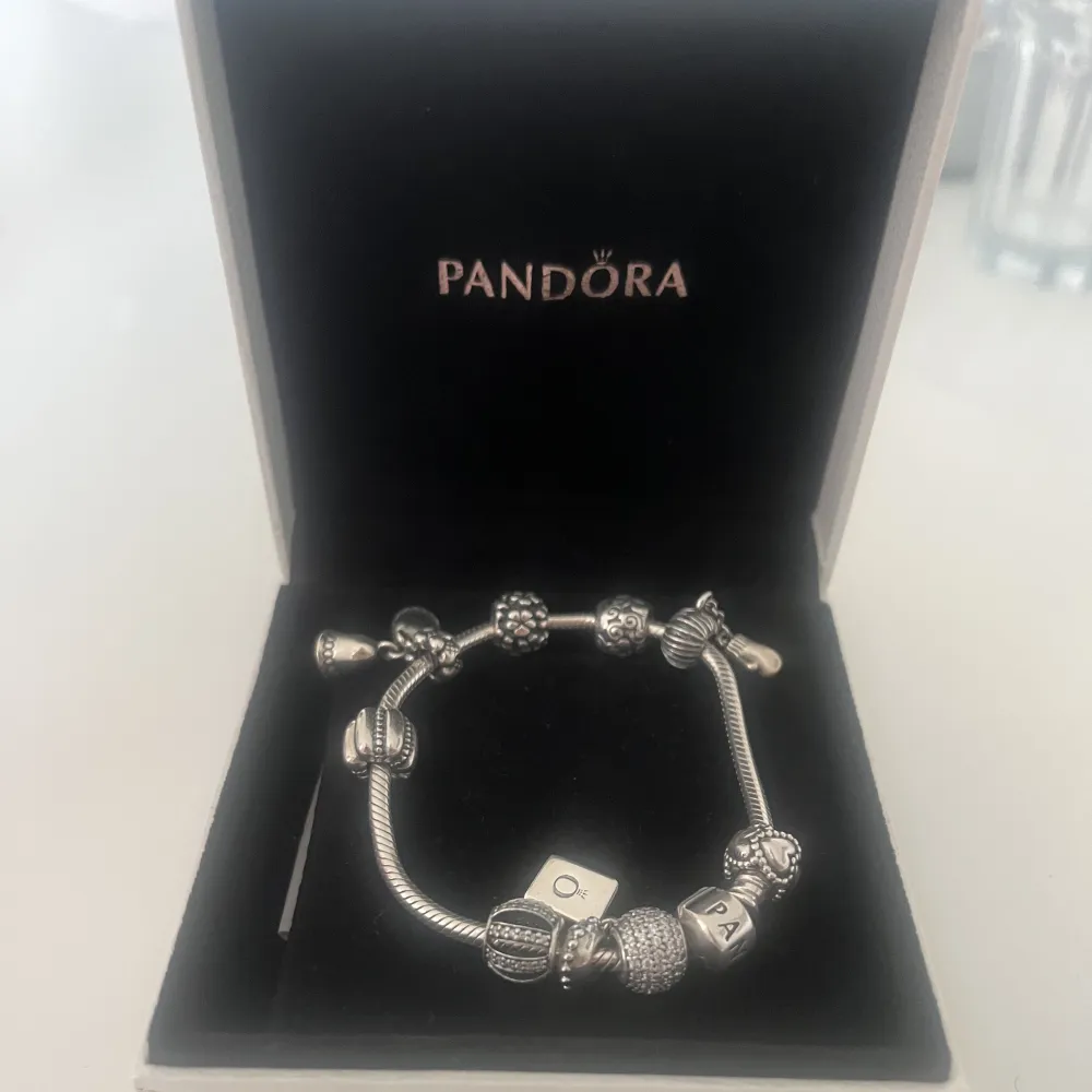 Hejsan! Säljer mitt fina Pandora armband då jag tyvärr ej använder silver längre :(  Armbandet har 9 berlocker var av en av dem är en stopper. Frakt ingår i priset. . Accessoarer.