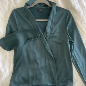 Grön skön blus - En blus från gina i storlek xs men passar s upp till m. Jag själv är i S/M och kommer i den utan problem. Den sitter skönt och bekvämt, blusen är i mycket bra skick.