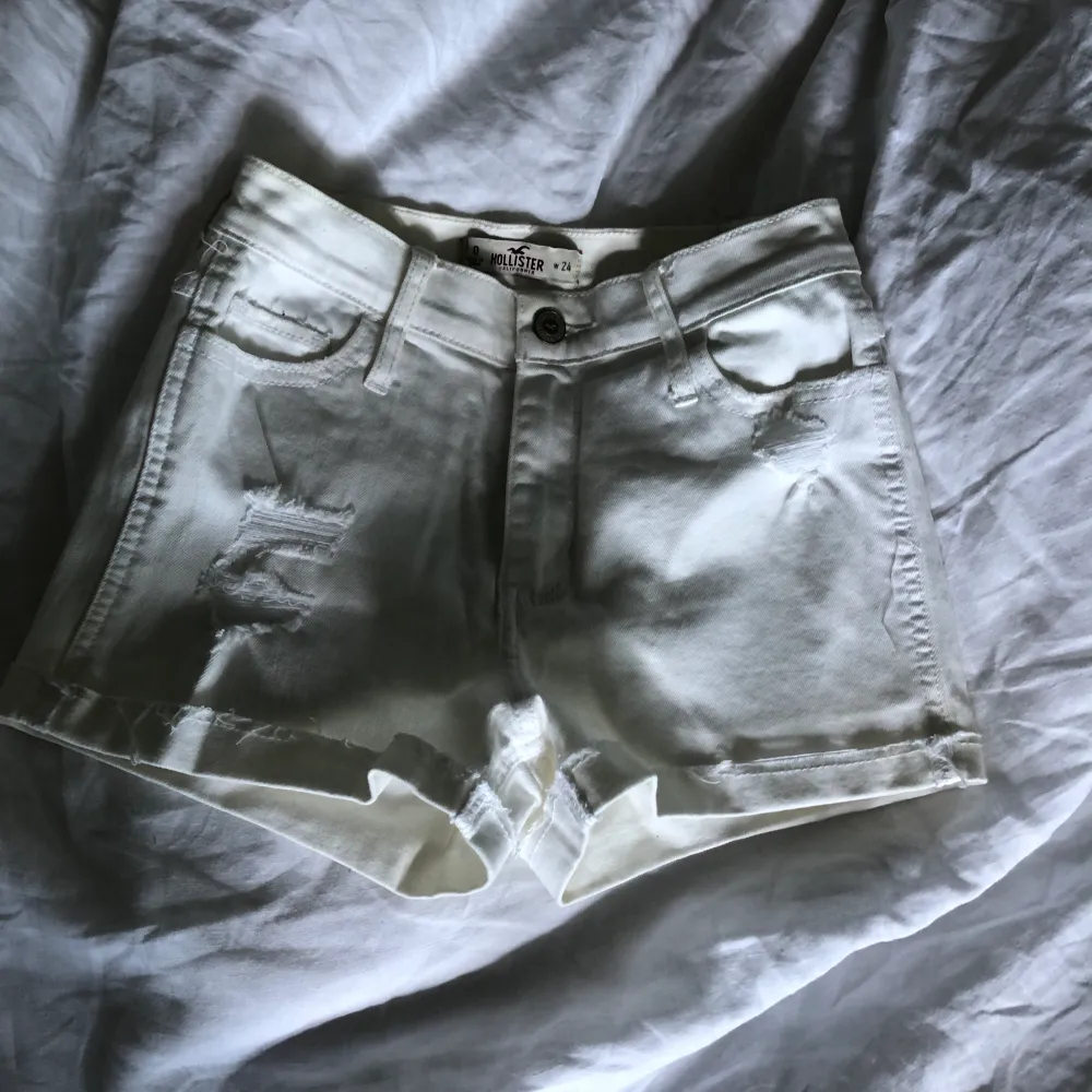 Högmidjade jeansshorts i vitt och lite slitningar från Hollister i storlek w24.. Shorts.