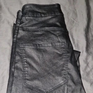 Skinnbyxor- Vero Moda Smooth Coated Pants - Härliga skinnbyxor från Vero Moda. Lite använda i god skick. Eu storlek 30. Dom har bra stretch og är komfortabla att ha på. 77% viscose 20% nylon 3% elastane. Hög midja och skinny fit.