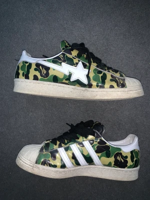 Adidas x bapesta superstar  - Vunna på trés bien raffle  Storlek 42,5 Fint skick 8/10 Inga hål eller trasiga på något sätt alls. Orginalkartong med alla tillbehör o laces medföljer. Ligger på runt 2500kr på stockx. 