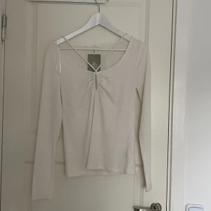 Topp - En tunn långärmad topp med snygg detalj framtill. Den är köpt på H&M och är aldrig använd (lappen kvar)