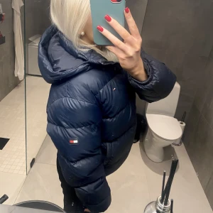 Tommy Hilfiger jacka  - Säljer min Tommy Hilfiger dunjacka eftersom att jag har köpt en ny jacka! Köpte jackan förra vintern och den är sparsamt använd och i fint skick. Mörkblå i strl 16 år. Sitter superfint och är håller värme bra. Köpt för 2099kr och säljer för 1100kr!❤️‍🔥