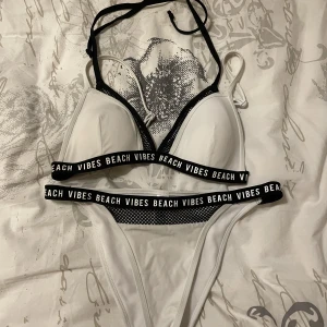 Bikini i storlek S från New Yorker - Så snygg bikini i storlek S från New Yorkers märke Censored. Den är så skön och kan både knäppas och knytas. Underdelen är "lågmidjad/midwaist" De vita banden går rakt över axlarna medan de svarta snörena knyts runt nacken. Bra skick! Knappt använd!