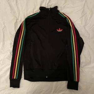 ADIDAS SST TRÄNINGSJACKA - tror de är av färgerna reggae/rasta. ny pris 850kr jdsports denna modellen. Hör av er vid mer frågor/bilder💯