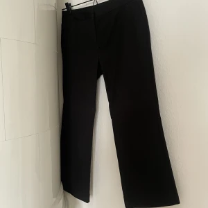 Kostymbyxa  - Croppad kostymbyxa i ”boxig” modell. Låg midja.  Snygg detalj med sömn under knät. 