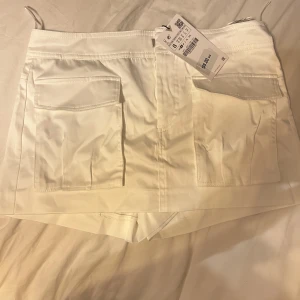 Mini kjol - Mini kjol med inbyggda shorts 90’s tema med fickor där fram. Cargo liknande mini kjol med jätte fina fickor!