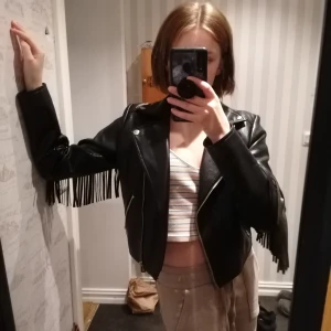 Skinnjacka med fransar - Cool skinnjacka fån bik bok med svarta (allt i fejkläder) fint skick och inga tecken på användning