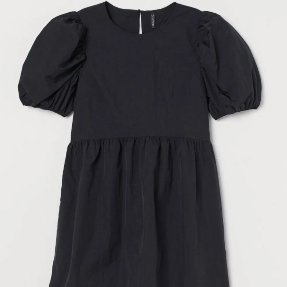 Kort svart klänning med lite puffärmar, tightare i ”överdelen” sen är den lite mer ”puffig” men inte så puffig i underdelen. Lite tunnare i materialet. . Klänningar.
