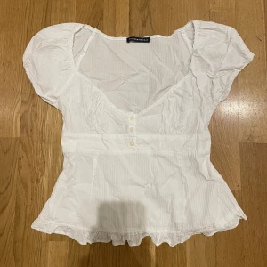 Vit blus - Säljer denna asgulliga blusen från brandy Melville. Använd 1-2 gånger så har inga defekter. För fler bilder/frågor kom privat🩷