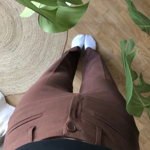 Bruna Kostymbyxor - Bruna kostymbyxor från monki, väldigt bra skick. Rak modell. Kommer aldrig till använding!  Jag är 168cm lång, sitter jättebra i midjan på mig som vanligtvis har storlek 36 🌟