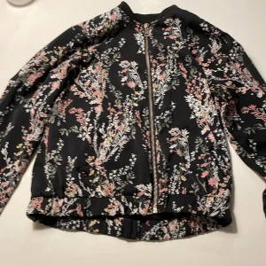 Blommig jacka - Jag köpte den begagnad, den är i bra skick och jag har knappt använt den! 