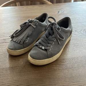 Ljusblå mocka sneakers från Mikael kors i fint, men använt skick. Plös med fransar går att plocka bort   Nypris 1499:-