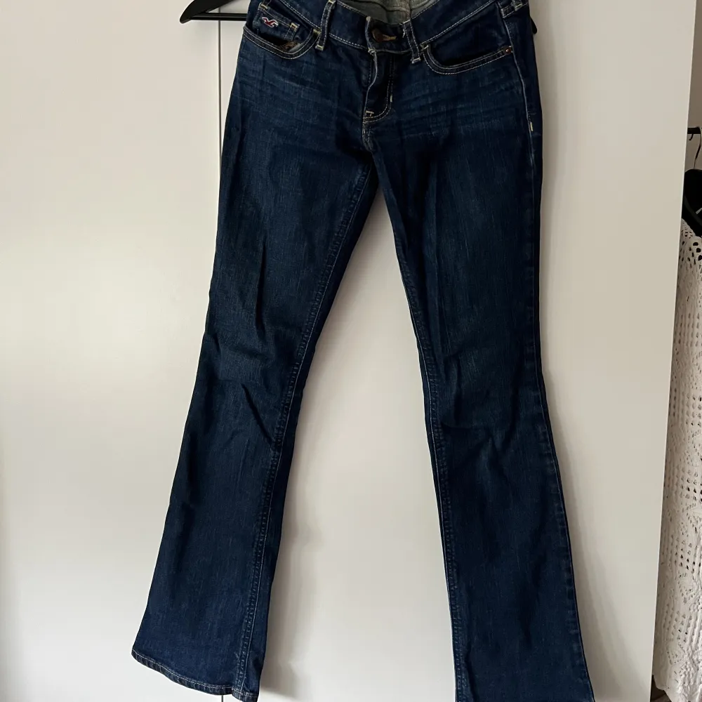 Mått: Jeansen är storlek 24 i midjan och i längden 31 Stil: Lågmidjade, mörkblå, bootcut Skick: Bra skick  Märke: Hollister. Jeans & Byxor.