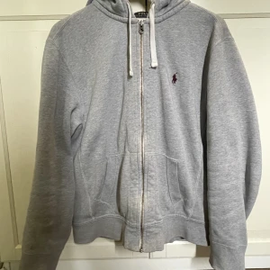 Ralph lauren zip hoodie - En grå Polo Ralph Lauren zip hoodie i mycket bra skick.  Passade inte mig i storleken. Skick:9/10.  Storleken är L men skulle kunna passa M Nypris är 1800