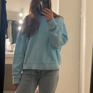  ljusblå sweatshirt  - Snygg ljusblå Hoodie de. Är i lite tunnare material så funkar toppen under alla årstider använd fåtal gånger och inga större skavanker.