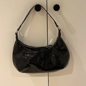 Svart Glansig Väska - Säljer denna fina glansiga väska då jag har för många väskor och behöver bli av med några, passar till både fest och vardagligt. Kan tänka mig gå ner i pris vid snabb affär, skriv för fler bilder☺️