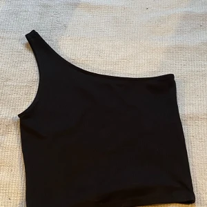 Svart topp  - Säljer en super fin topp med 1 axel❤️ inga defekter
