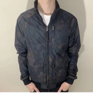 SÄLLSYNT Woolrich windbreaker - Snygg camojacka från Woolrich i grymt skick, inga defekter. Går att vända ut och in för en ny jacka. Sällsynt, säljs ej längre. Storlek M. Modellen är 180 cm. Nypris 2800kr. Vårat pris 899kr. Skriv vid minsta fundering!📩