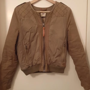 Fodrad Lee jacka - Fodrad jacka, märket Lee. Snygg passform, brun och brungrönt tyg. "Teddy"foder.