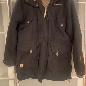Didriksson Vinterjacka L - Varm Vinterjacka svart i strl L. Använd en säsong, fint skick. Halvlång slutar strax ovanför knäna. 