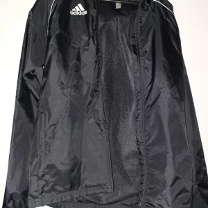 Wct adidas vindresistent löparjacka - En helt oanvänd adidas vindresistent,vattenavvisande löparjacka  med huva.Är storlek small. Säljer pågrund av felköp.Kan inte byta då jag råkat kasta kvittot.