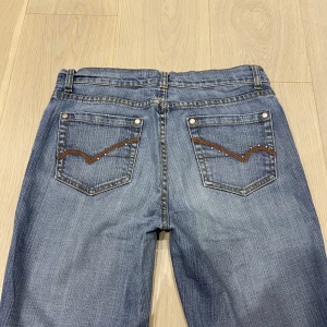 lågmidjade/midwaist jeans med bootcut💕 - rhinestones på fickorna! midja 82 cm innerben 73 cm ja e 170 för referens o de e för korta för mig 