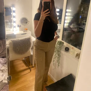 Cargobyxor - Brun/beiga cargobyxor från Stradivarius, storlek 38,  högmidjade, går ner till ankeln på mig som är 173cm