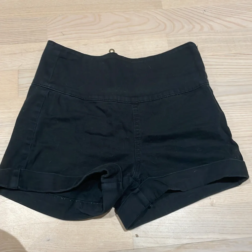 Ett par högmidjade shorts i färgen svart med en guld aktig kedja på baksidan. Inte så korta shorts 💓. Shorts.