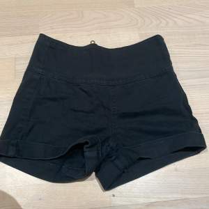 Ett par högmidjade shorts i färgen svart med en guld aktig kedja på baksidan. Inte så korta shorts 💓