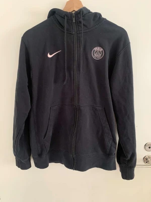 Svart psg hoodie  - Jag säljer en svart psg hoodie. Har använt men den har inga fläckar, hål eller något Säljer eftersom inte vänder den längre alls Om du är intresserad o vill köpa måste du oxå betala frakten Den är inte så tjock heller så den e bra till sena sommarkvällar💕
