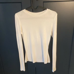långärmad tröja med slit - vit långärmad tröja med slits vid sidorna, väldigt skönt material. Man kan ha tröjan på båda sidorna! 😁