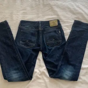Blåa låga jeans i en mörk tvätt, raka och väldigt långa i benen!