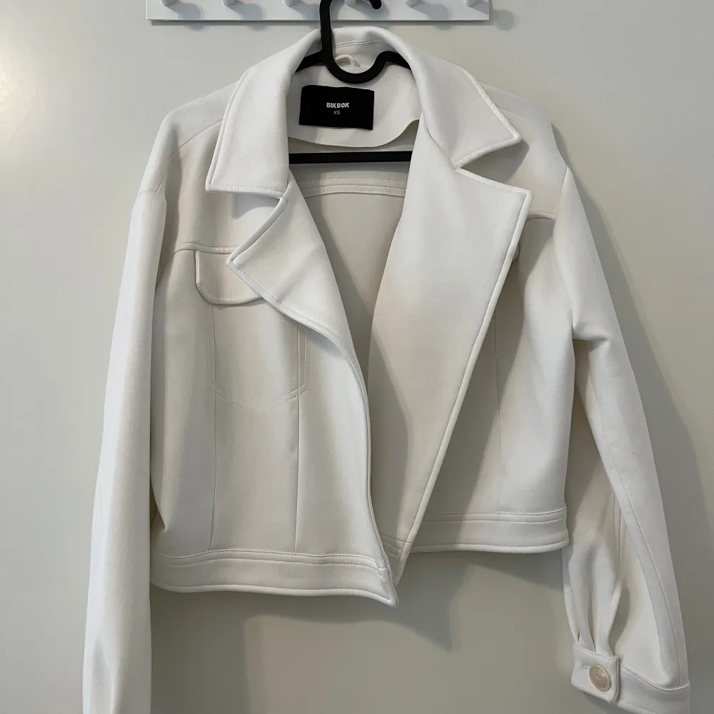 Fin cropped vit satin jacka i nyskick. Jackan är lite oversized. Materialet är luftigt och skön passar perfekt till vår och sommar. . Jackor.