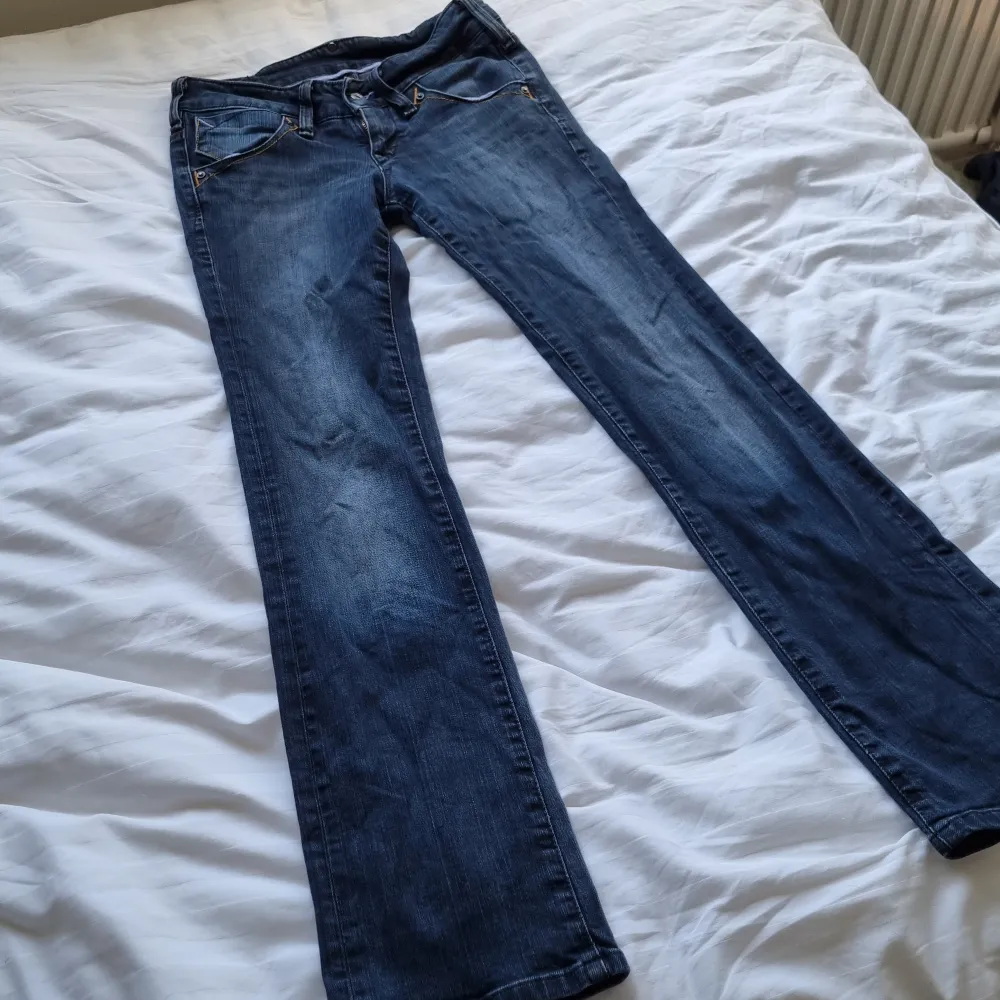 Lågmidjade jeans från Lee i bra skick. Rak, med något utsvängt i modellen. Färgen är lite grå/blå. Strl 27/31 Midja: 35 cm Innerbenslängd: 77 cm Ytter: 96 cm. Jeans & Byxor.