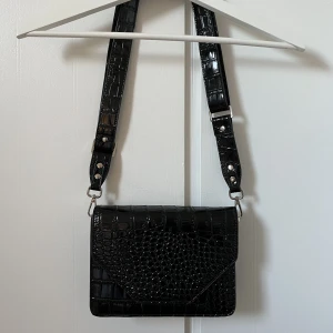 Unlimit väska - Svart glansig unlimitväska i fakeormskinn. Ordinarie pris är 524 kr. Köpare står för frakt💋