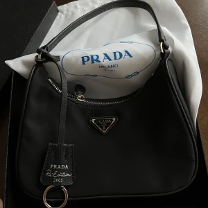 Prada väska - Prada Re-Edition 2005 Re-Nylon mini bag.    Har tyvärr slarvat bort, äkthetskortet som tillhör väskan. 