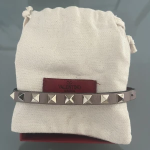 Valentino armband  - Ljuslila Valentino armband med dustbag och låda!  Den har lossnat i slutet av bandet men de kan man enkelt limmas ihop! Annars fint skick!