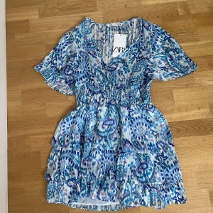 ZARA klänning  - Säljer denna superfina klänning pga hann inte lämna tillbaka. Helt oanvänd med prislapp kvar, nypris 399 kr. Köparen står för frakt💕 (säljer likadan fast med gröna detaljer istället för lila i storlek S)