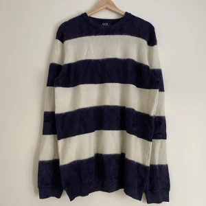 APC, oversized glansig/mohair blåvit randig kofta - En oversized blåvit randig kofta från APC. Gjort av ett väldigt speciellt material (39% polyamid, 30% viskos, 20% mohair, 10% ull, 1% elastan). Har en glansig look. Punk looken😎😎  Sitter väldigt oversized, är väldigt stretchy. Sitter typ som L-XL.   