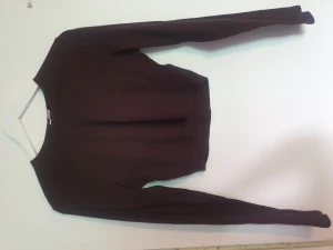 Topp - Långärmad kortare tröja. Den är ribbad och går ganska högt upp i urringningen. Aldrig använd bara testad.